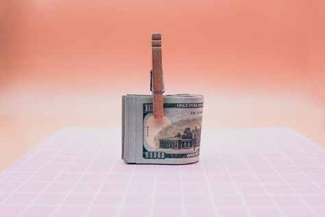 Rolled banknotes secured with a strap on a minimal surface, symbolising investment, capital and financial confidence.