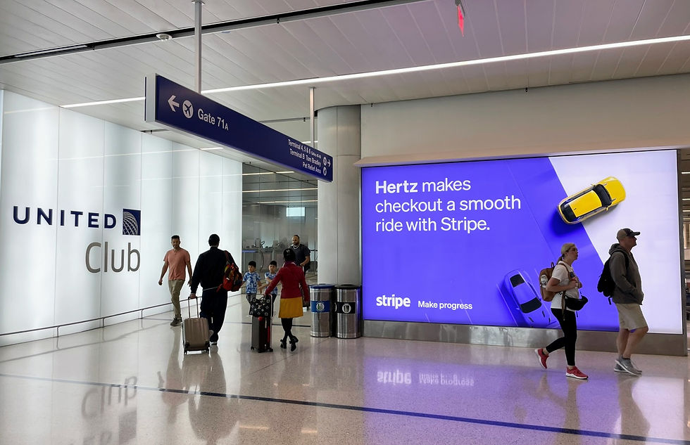 Stripe brand advertising displayed in an airport terminal, showing a large digital billboard promoting smooth checkout for Hertz, illustrating high-reach brand building in a real-world buying context.