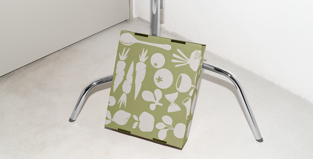 Free Cardboard Box Leaning Against the Tripod Mockup.png