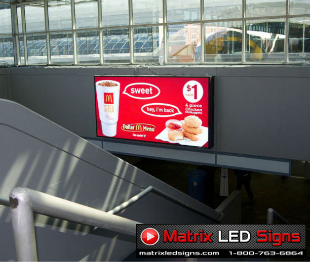 Matrix LED indoor display showing a McDonald’s dollar menu promotion inside a stadium concourse.