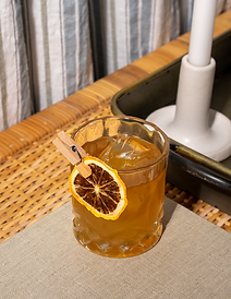 Sazerac cocktail on table mat, on top of wooden woven table.