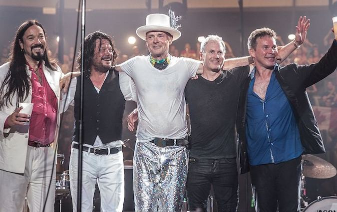 The band with their arms on each other's shoulders at the end of the concert