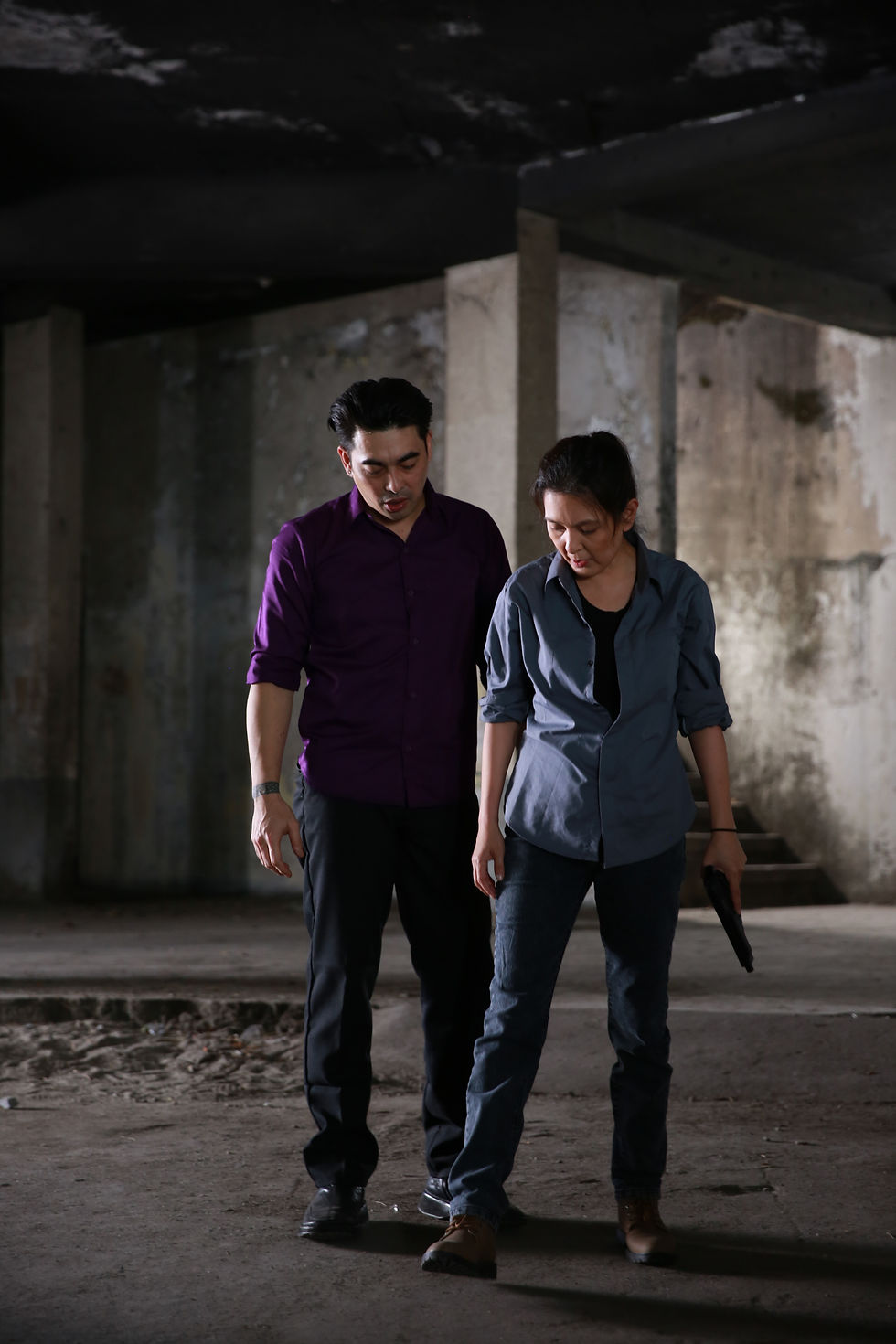 Two performers standing in a dim concrete interior — CineBandits production gallery