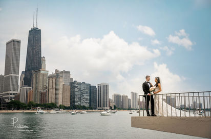 Couple embraces at the waterfront overlook in Milton Lee Olive Park, with Lake Michigan and the Chicago skyline behind them.