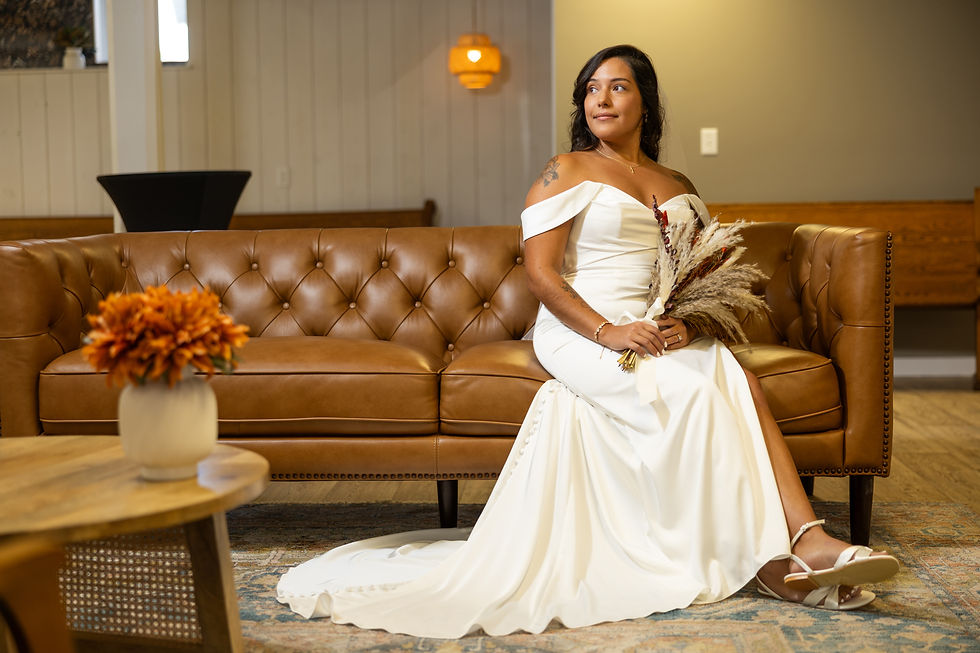 Anna’s bridal portrait on a brown leather sofa with her dried-flower bouquet.