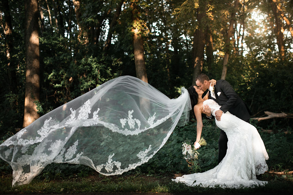 Groom dipping and kissing his bride beneath her veil in Oak Brook, Illinois