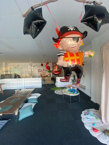 Pirate theme birthday party at our venue set up with balloons, sensory trays and boho timber floor trestle with floor cushions.