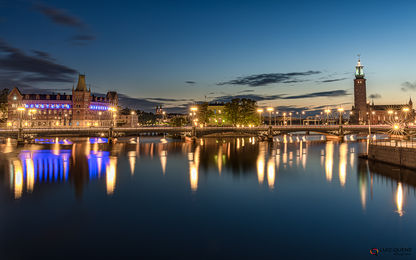 A Ponte Vasabron, que liga os bairros Normalm e Gamla Stan sobre o canal Norrström com seus reflexos das luzes noturnas, Estocolmo, Suécia