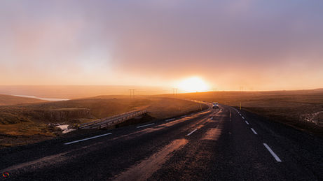 Um surpreendente pôr do sol sobre densa névoa na Route 93, Seyðisfjördur, Islândia