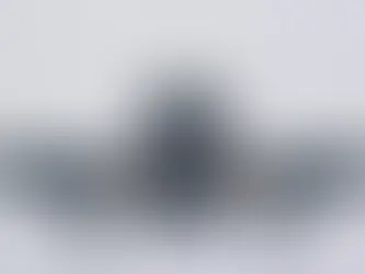 A plan flying in the sky on a cloudy day.