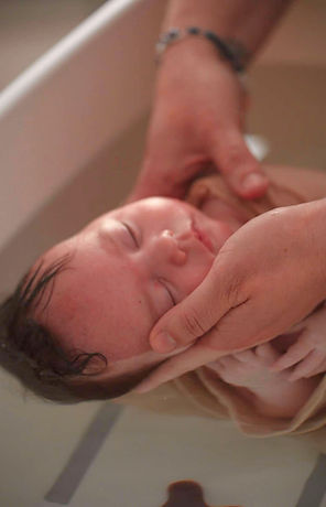 nouveau bénéficiant d'un bain au domicile des parents, endormi grâce à la chaleur de l'eau