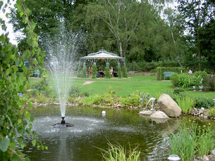 MartinsHof Grabow | Im Vordergrund ist eine Wasserfontäne, im Hintergrund der Sonnenpavillon zu sehen.