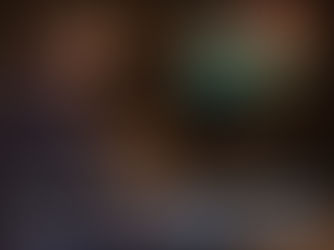 Smiling person in a cozy room playing a retro video game on a CRT TV. Shelves of books and a lit fireplace create a warm atmosphere.