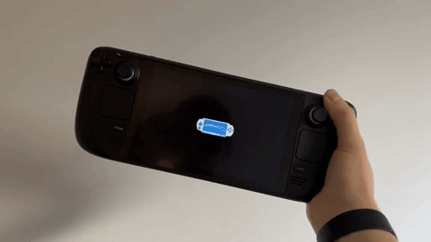 Hand holding a black gaming device with a blue progress bar on the screen. The background is plain white.