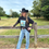 Thumbnail: Woman leaning on fence wearing black cowboy hat and shirt; Southern Grace Boutique.