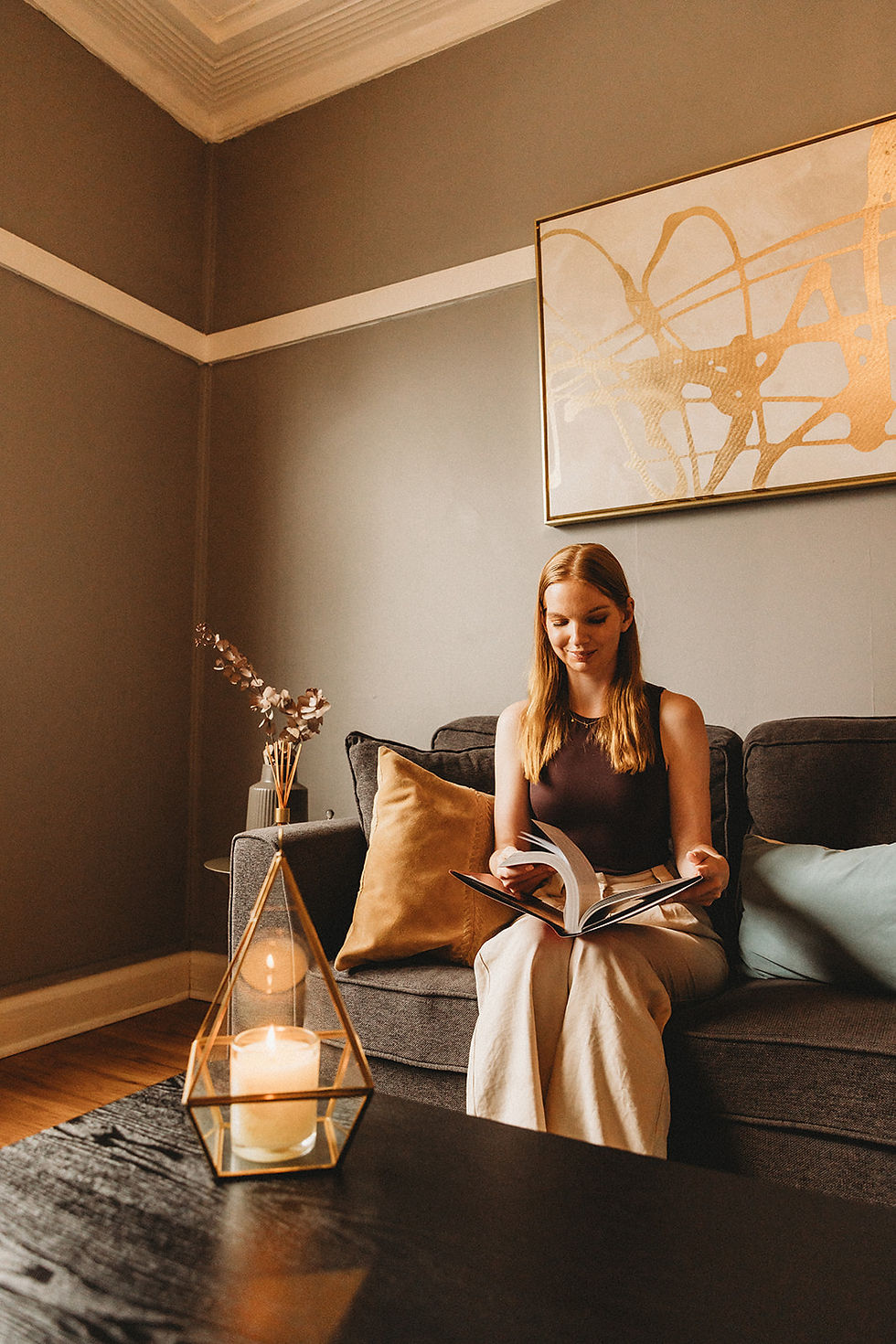 Stacey Van Der Meer, a Psychologist at Lucent Psychology, sitting on a grey couch flicking through an open book