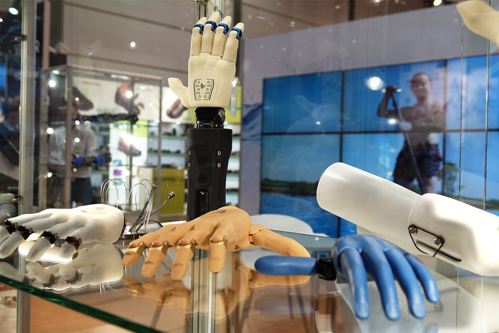 Verschiedene Handprothesen und Prothesenhände in unterschiedlichen Ausführungen werden auf einer Messe in einer Glasvitrine präsentiert