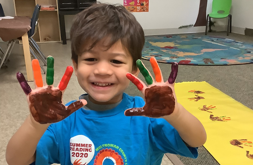Discoveryland child creating a turkey using handprint finger paint.