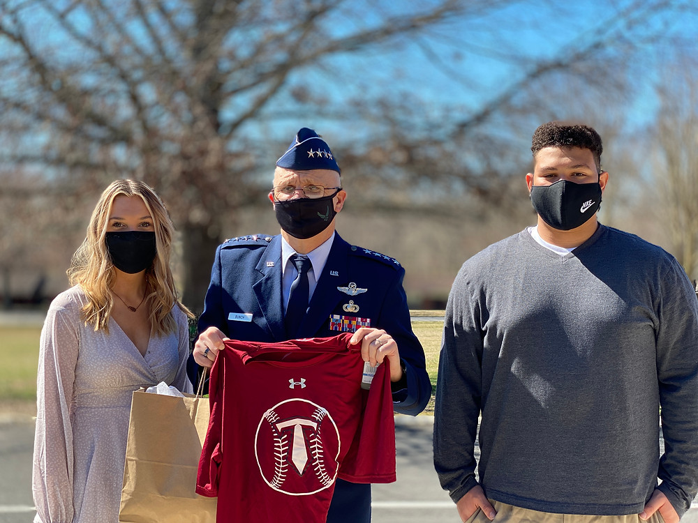 Air Force General Arnold Bunch Jr. holds a baseball t-shirt presented to him by Emmalee Stubblefield and Jaiden Picardi