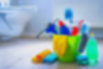 Various cleaning items and supplies in a bucket on the bathroom floor_edited.jpg