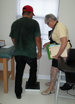DEO Volunteer weighing patient.JPG