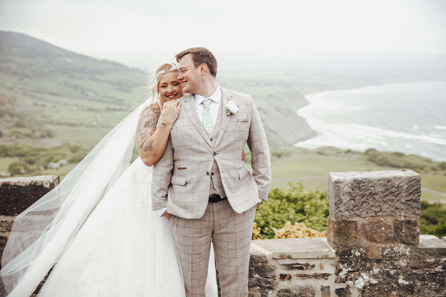 Wedding couple Samanta & Daniel hugging while overlooking the ocean at Raven Hall Country House Hotel, natural documentary-style wedding photography on the Yorkshire coast.