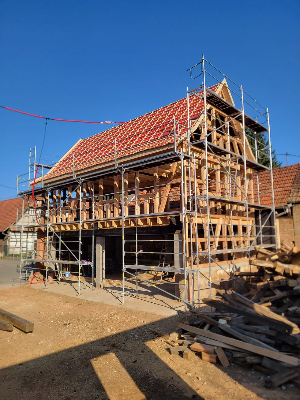 Vue à hauteur d’œil de la maison alsacienne rénovée avec ses poutres apparentes et toiture en tuiles