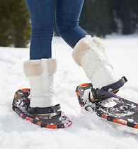 happy young couple having fun and walking in snow shoes outdoor in nature at beautiful wi