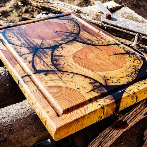 Ein auffälliges Schneidebrett aus Holz eines alten Telegraphenmastes und schwarzem Epoxid-Harz. Ein echter Hingucker.