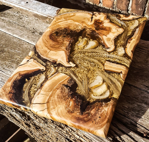 Ein dekoratives Schneide- und Servierbrett aus altem Apfelholz und Getreide, Hafer und Weißbrotscheiben, eingegossen in glasklarem Epoxid-Harz.