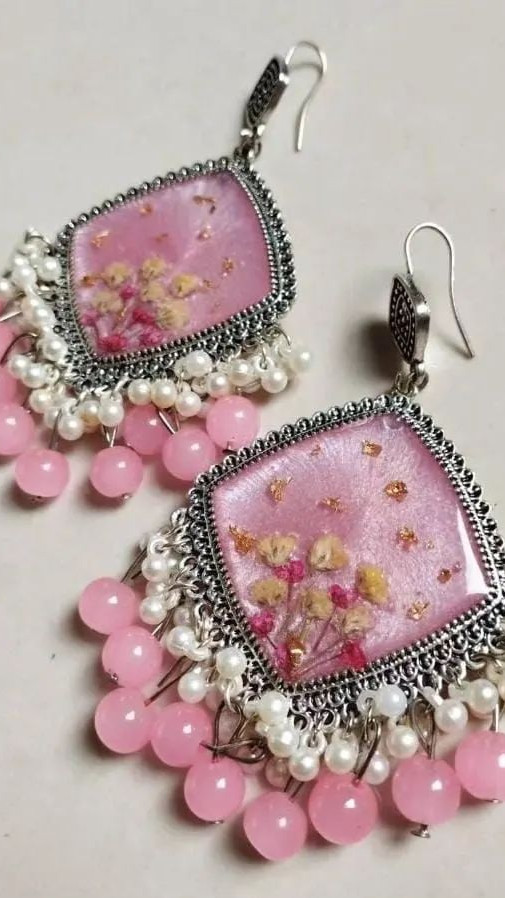 Handmade floral resin jhumka earrings with golden pearl details and matching studs, displayed professionally for Salsabila Academy's resin workshop