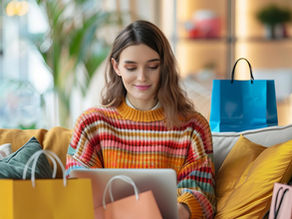 A woman sitting on a sofa while online shopping on her laptop