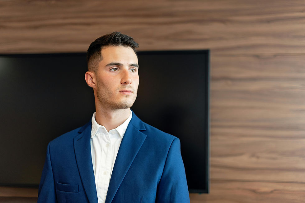 A founder gazes thoughtfully to the side in a room with wood paneling.