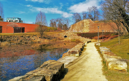 Pohled na Kamennou baštu XI a rybníček na potoce Brusnice v parku Max van der Stoela