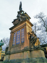 Vrcholová socha na hlavním pohřebním pylonu Génius nad rakví je z dílny sochaře Josefa Maudera