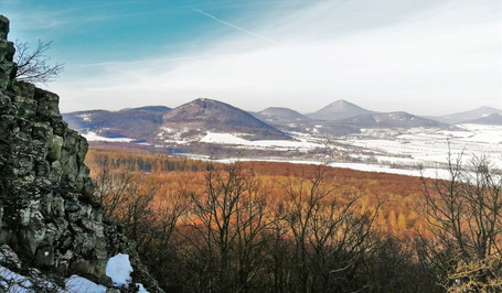 Omračující pohled z Oltáříku, v popředí je Lipská hora se svým zajímavým tvarem; v zadní partii více vpravo s malou stavbou na vrcholu je nejvyšší hora Českého středohoří Milešovka