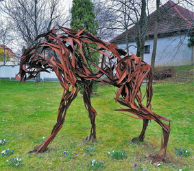 Hyena je dílo sochaře Jana Dostála, vzniklo z kovových dílů a socha v Dolních Břežanech je zajímavá tím, že není povrchově uzavřená