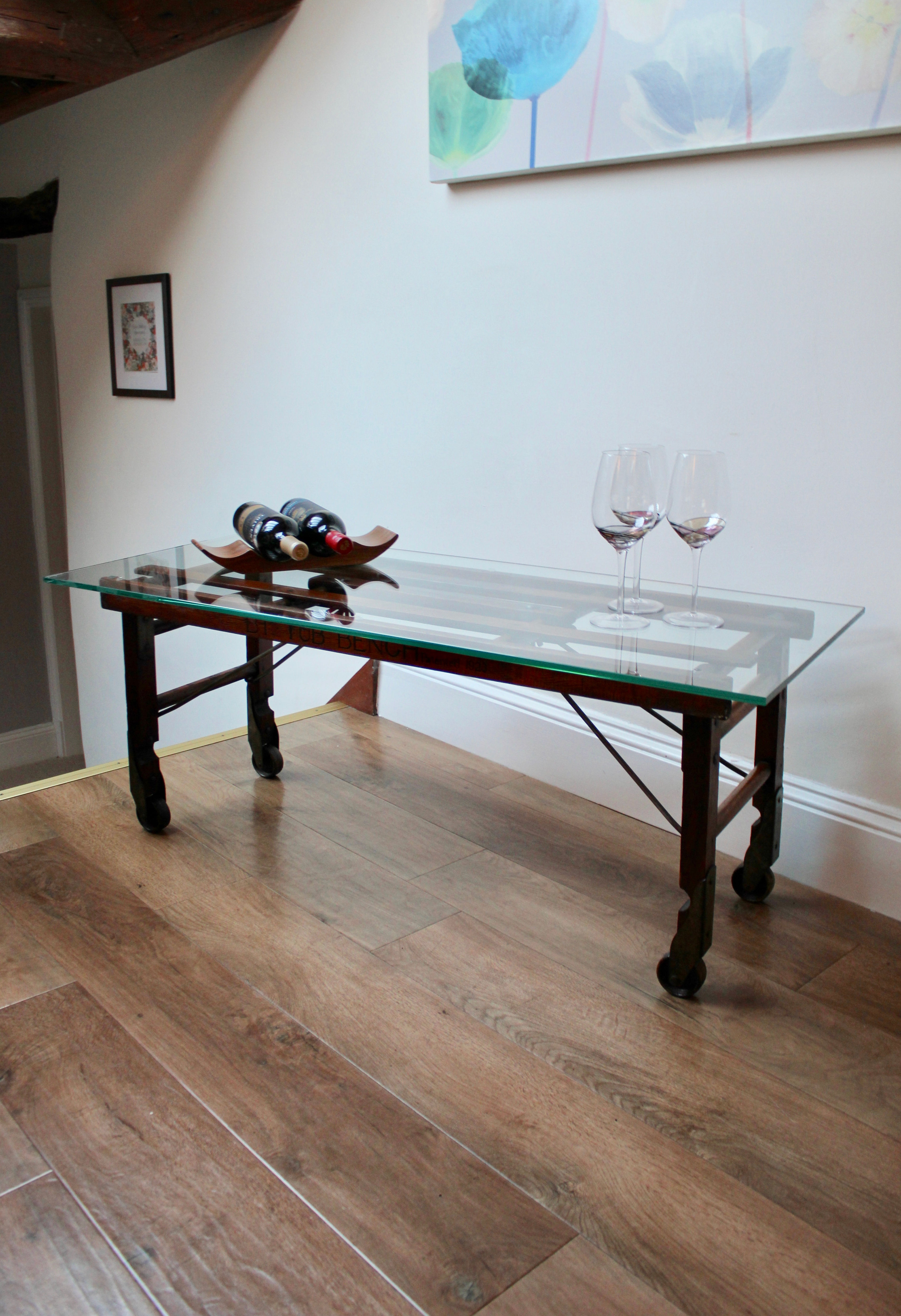 Glass Topped Coffee Table with Wooden Base on Castors.