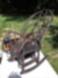 Antique dark metal rocking chair with scrollwork
