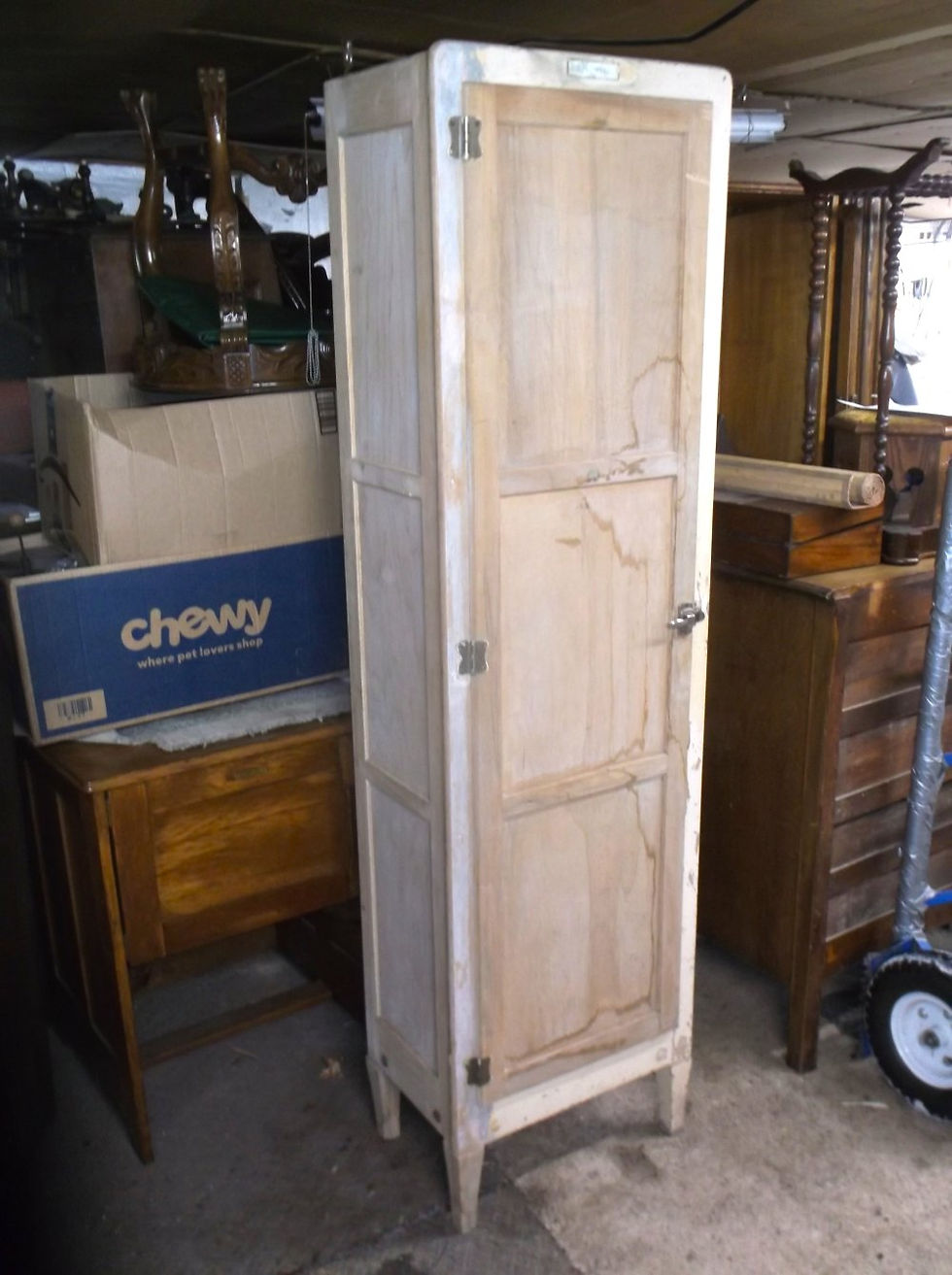 Exterior view of tall painted broom closet with aged finish
