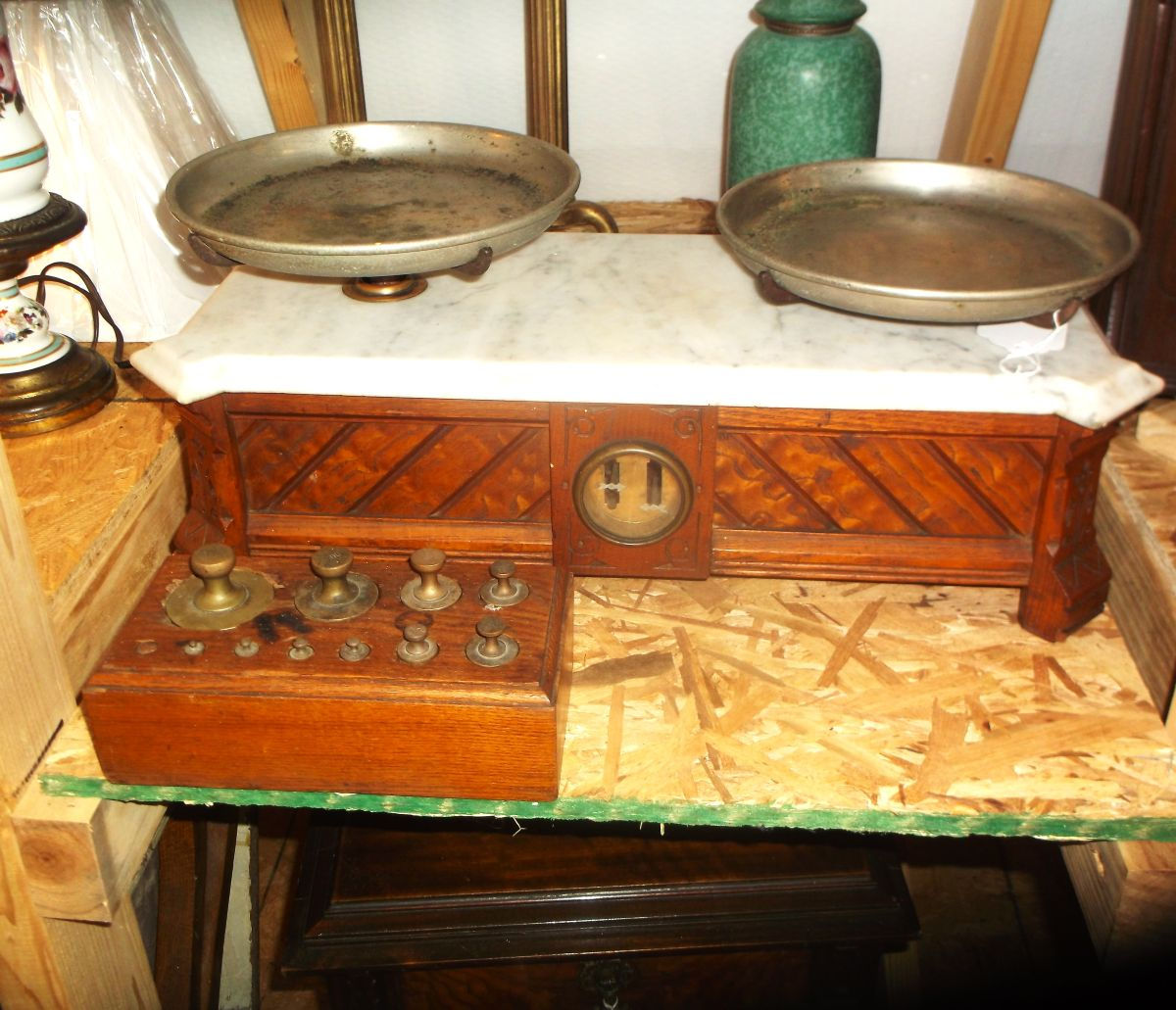 Front view of marble top balance scale with weights