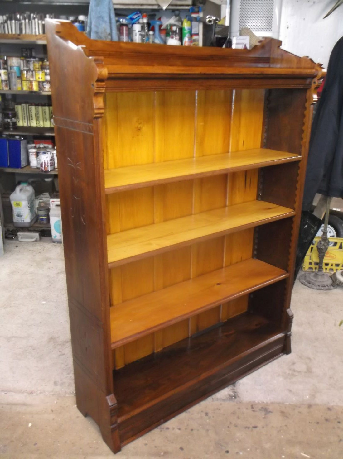 Victorian open bookcase with four shelves and carved scrolling details on the sides