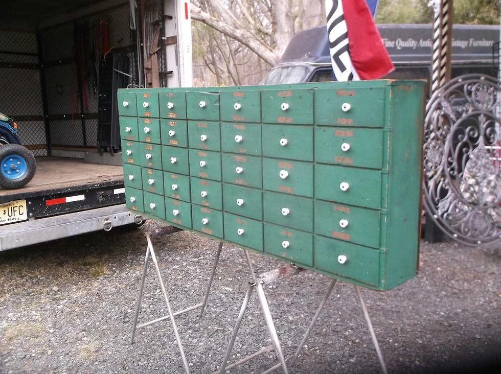 Side view of wooden display cabinet with 35 drawers in green paint