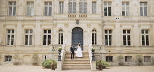 Bride and groom walking down the grand staircase at Château de la Valouze.