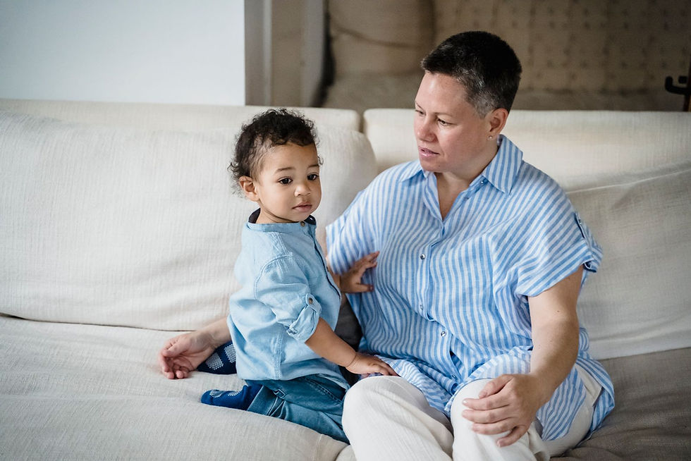 A mother and child sitting quietly together on a couch, representing the daily attunement that supports an adopted child who may have FASD