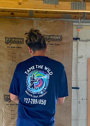 Image of insulation expert, Ryan, wearing a Wild Elements Solutions company shirt while installing Fi-Foil on a job site in South Tampa.