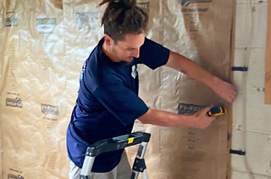 Image of Wild Elements Solutions insulation expert installing Fi-Foil on a residential project in Tampa, FL, improving thermal performance and reflecting radiant heat for year-round comfort.