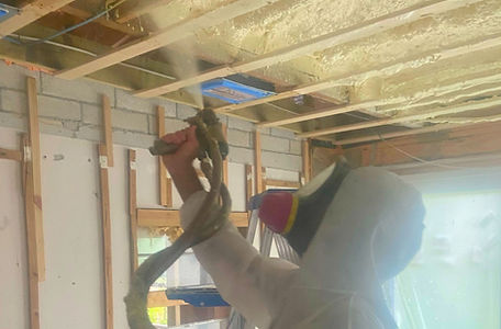 Wild Elements Solutions insulation expert applying open-cell spray foam, creating an effective air seal to boost energy efficiency, reduce noise, and improve indoor comfort.