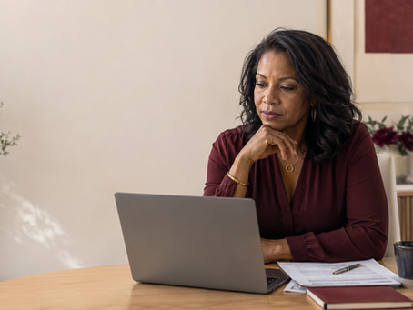 Mid-career Black woman reviewing a laptop, résumé, and job-search plan in a warm professional workspace, with visual prompts about modern hiring, networking, adaptability, and professional growth.