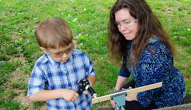 Jennie Harriman teaches woodworking to a child